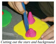 A student working on clay. Yellow, flat rectangle with two gray cones of different heights.