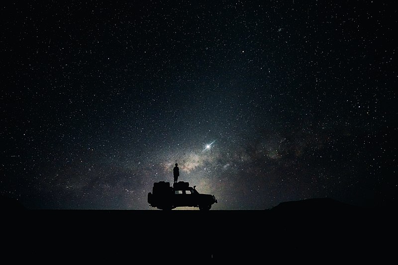 Image, 'Looking at the Night Sky'; stars in background, people looking at them in foreground.